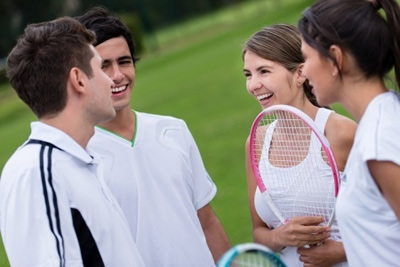 Group enjoying a game of tennis on a court on a holiday park